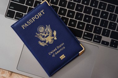 ABD pasaportu klavyede, modern seyahat, dijital kimlik doğrulaması ve uluslararası belgeleri sembolize ediyor.