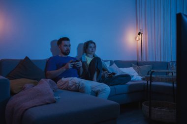 Çift, geceleri rahat oturma odasında video oyunu oynuyor..