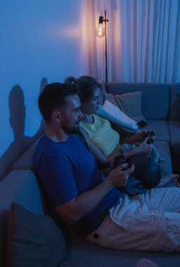 Çift, geceleri rahat oturma odasında video oyunu oynuyor..