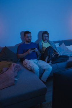 Çift, geceleri rahat oturma odasında video oyunu oynuyor..