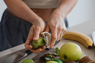 Mutfakta Elmalı ve Muzlu Taze Kiviyi Soyan Kadın.