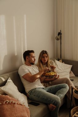 Bir çift sıcak lving odasında patates kızartması ve tavuk nugget paylaşıyor..