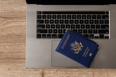 ABD pasaportu klavyede, modern seyahat, dijital kimlik doğrulaması ve uluslararası belgeleri sembolize ediyor.