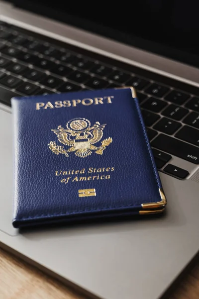 ABD pasaportu klavyede, modern seyahat, dijital kimlik doğrulaması ve uluslararası belgeleri sembolize ediyor.