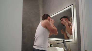 Günlük Bakım Programında Deriyi Aynadan İnceleyen Adam.