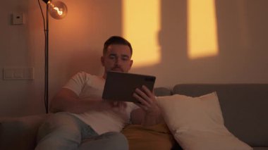 Evdeki Konforlu Bir Akşamda Tablet 'e Bakan Adam.