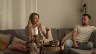 Çift Evde Kanepede Atıştırmalık ve Sohbetin Tadını Çıkartıyor.