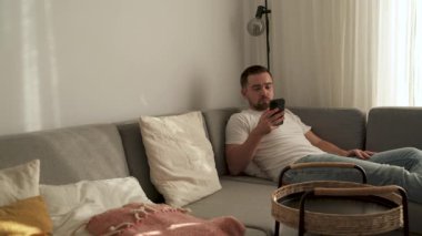 Rahat Adam Evdeki Kanepede uzanırken Akıllı Telefona Bakıyor.