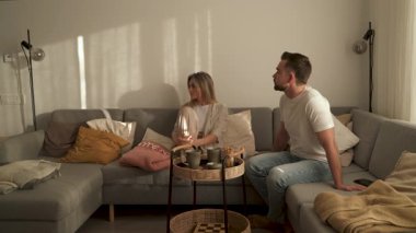 Çift Evde Kanepede Atıştırmalık ve Sohbetin Tadını Çıkartıyor.