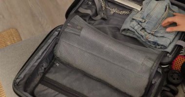 Kadının kişisel eşyalarını evdeki sert bavula koyup seyahate ya da tatile hazırlanması..