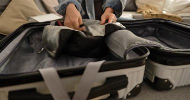 Kadının kişisel eşyalarını evdeki sert bavula koyup seyahate ya da tatile hazırlanması..