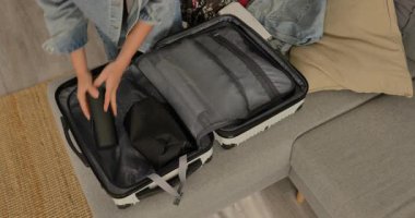 Kadının kişisel eşyalarını evdeki sert bavula koyup seyahate ya da tatile hazırlanması..