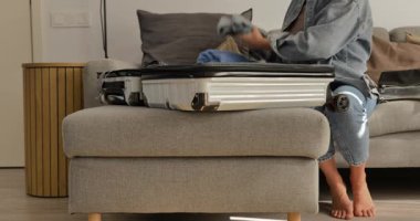 Kadının kişisel eşyalarını evdeki sert bavula koyup seyahate ya da tatile hazırlanması..