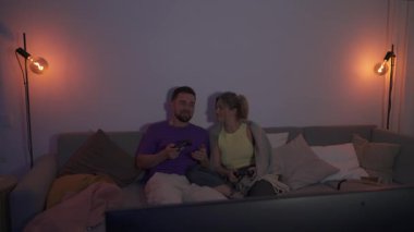Çift, geceleri rahat oturma odasında video oyunu oynuyor..