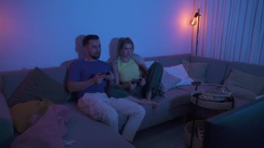Çift, geceleri rahat oturma odasında video oyunu oynuyor..