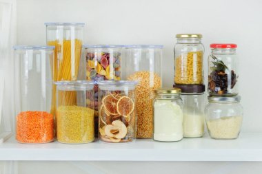 Tahıl ürünlerinin çeşitliliği ve beyaz ahşap masadaki cam kaplarda makarna. Sağlıklı yemek, temiz yemek, sıfır atık konsepti. Dengeli diyet yemekleri.