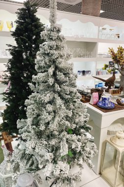 Avrupa 'da Noel ağacı satılıyor. Noel süslemeleri süpermarkette satışa hazır. Alışveriş merkezinde beyaz dekorasyonun çeşitliliği.