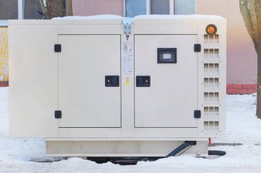 Güç kaynağı jeneratörü sokak kaldırımına yerleştirilmiş. Kışın dışarıda büyük bir dizel jeneratör çalışıyor. Enerji bağımsızlığı ve bakımı.