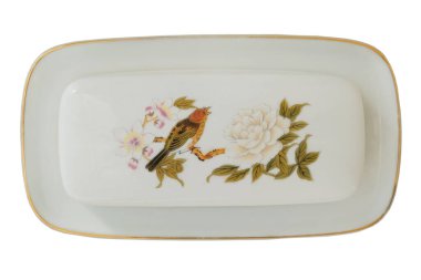 Tereyağı tenekesi. Süslü seramik yemek takımı. Üst Manzara. Tereyağı için porselen kabı beyaz arka planda izole edilmiş bir kuş deseni var..