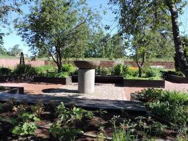 Bahçedeki taş kazan, ağaçlar ve çiçeklikler, Kotka, Finlandiya