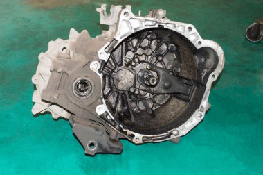 Arabadan çıkarılan manüel şanzıman oto tamirhanesinin yeşil katında duruyor.