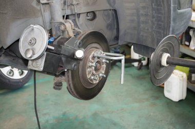 Araba tamir atölyesindeki özel ekipmanla arabanın ön fren diskini oluğa hazırlıyorum.