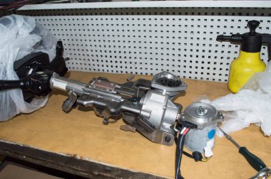 Elektrikli güç kaynağı olan direksiyon kolu otomobil tamirhanesinde, masaüstünde duruyor.