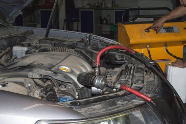 Otomobil tamir atölyesindeki motor soğutucusunun yerine özel bir cihaz yerleştirilmiş.