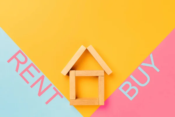 rent buy. a house made of wooden cubes with rent and buy inscriptions on colorful backgrounds