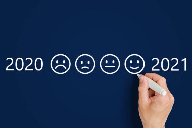 Erkek el, 2020 ve 2021 rakamlarının yanında hüzünlü ve komik ifadeler çizer.