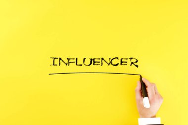 Adam sarı arka planda bir kalemle 