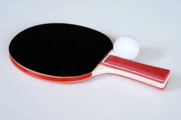 Table tennis paddle and ball on white background.