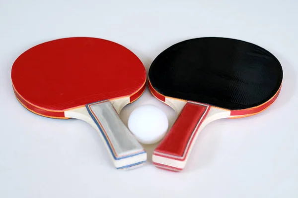 Table tennis paddle and ball on white background.