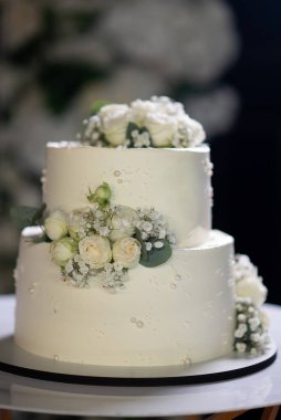 Beyaz çiçekli düğün pastası tasarımı.