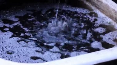 Yağmur damlaları büyük bir küvete düşer. Sağanak. Yağmurlu hava