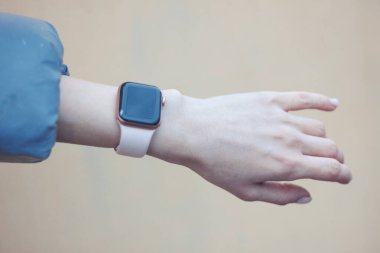 Bir kadının elindeki akıllı saat. Bej arkaplan