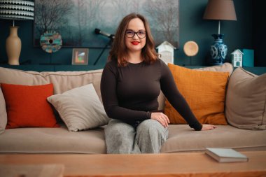 Gündüz vakti rahat bir duruşla koltukta oturan psikolog.