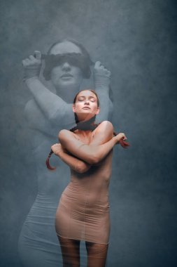 Model, yaratıcı bir sanat oturumu sırasında bir stüdyo ortamında sisli ve gölgeli pozlar verir.