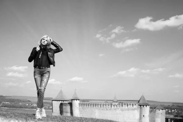 Khotyn要塞背景上一个穿牛仔裤和皮夹克的女孩的横向照片 — 图库照片