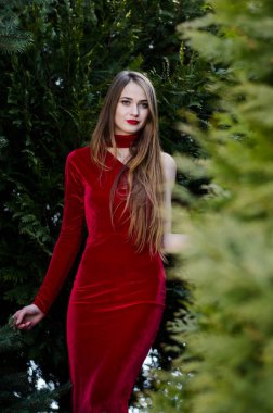 Güzel dikey portre. Şehvetli bir kadının görüntüsü. Yükselmiş ve rengarenk. Sokakta kırmızı bir elbise giymiş..