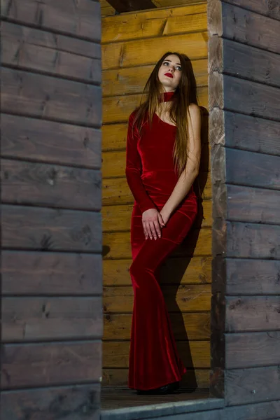 美丽的垂直肖像 穿着红色连衣裙的性感女人的形象 身材魁梧 在一间木制房间里摆出姿势 — 图库照片