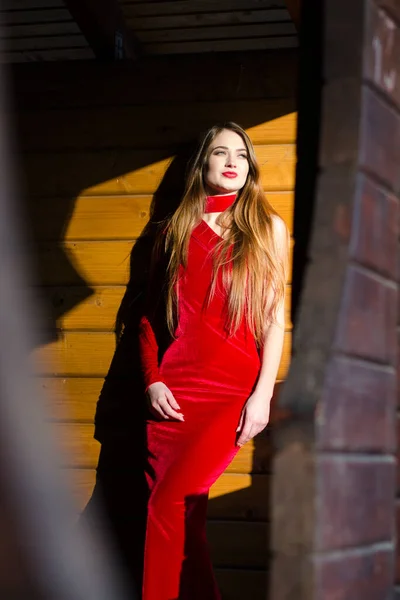 美丽的垂直肖像 穿着红色连衣裙的性感女人的形象 身材魁梧 在一间木制房间里摆出姿势 — 图库照片