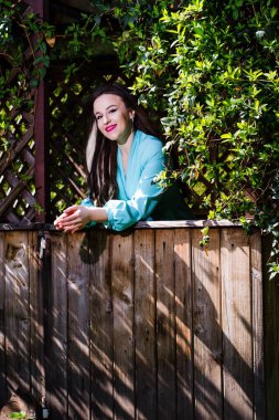 Çardakta elbise giymiş bir kızın dikey portresi..