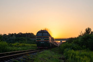 CHERNIVTSI OBlast, UKRAINE - 16 Ağustos 2021. Lokomotif 2M62u-0347 Chernivtsi oblast 'da gün batımında.