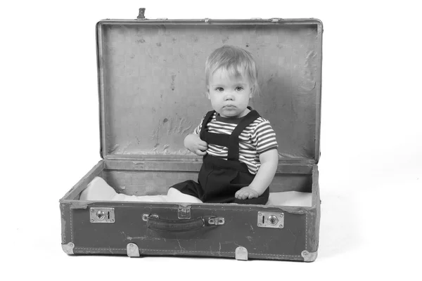 Jovem sentado em uma mala — Fotografia de Stock