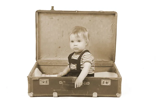 Niño sentado en una maleta — Foto de Stock