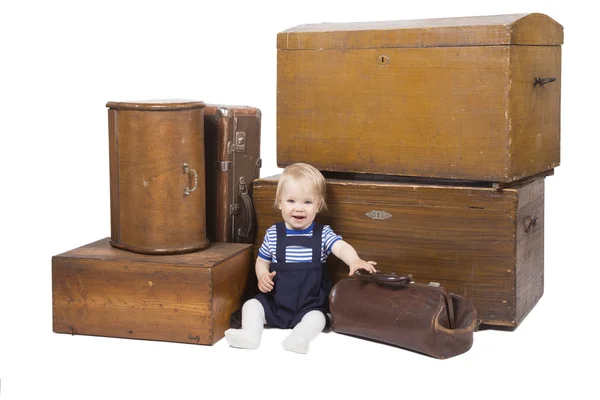 Jeune garçon avec de vieilles valises et boîtes — Photo