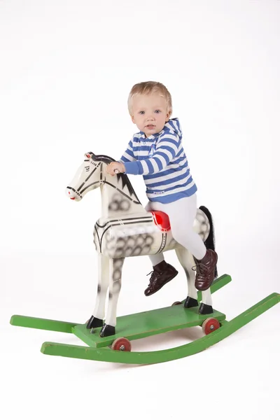 Ragazzo e cavallo a dondolo in legno Fotografia Stock