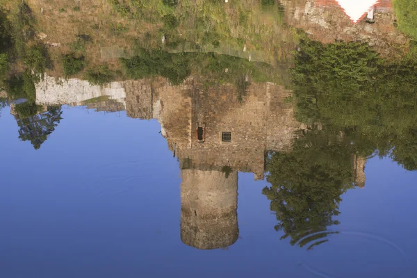 Reflexão da velha ruína na água — Fotografia de Stock