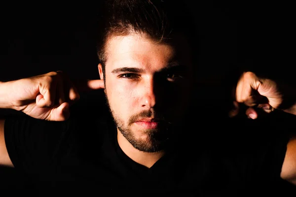 Young man puts fingers in his ears — Stock Photo, Image